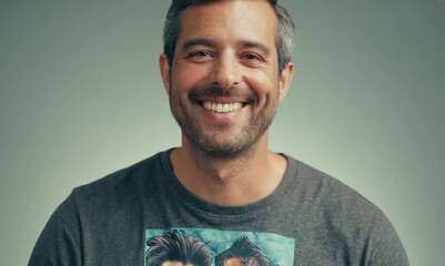 Wall Mural - Portrait of a handsome man smiling at the camera over gray background