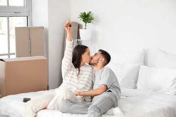 Wall Mural - Young couple with keys kissing in bedroom on moving day