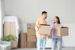 © Pixel-Shot - Young couple with cardboard boxes in room on moving day