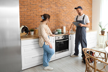 Sticker - Male technician with woman near broken oven in kitchen