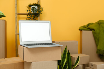 Wall Mural - Blank laptop on moving box in room, closeup