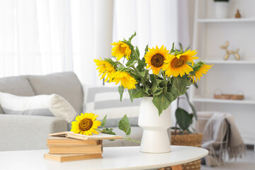 Wall Mural - Vase with sunflowers and books on table in light living room