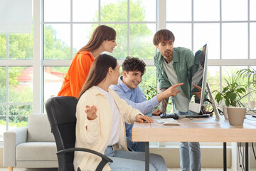 Team of programmers working with computer at table in office