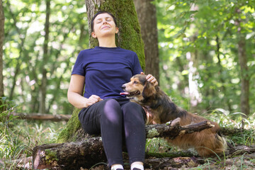 Wall Mural - Woman hiking with a dog in the woods