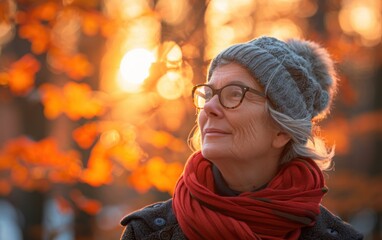 A person admires the beauty of autumn foliage while participating in a guided nature walk as the sun sets behind the trees