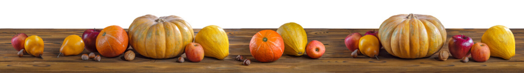 Wall Mural - Thanksgiving day pumpkin harvest on a white isolated background. Squash, orange vegetable autumn fruit, apples, and nuts on a wooden table for traditional Halloween decoration fall design