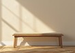 © Trident - Natural wood bench with beige fabric cushion on beige concrete wall and parquet floor in natural sunlight