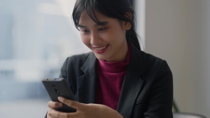 Wall Mural - Asian woman looking at mobile phone and smiling, Enjoying on smart phone