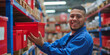 © Abee - A smiling warehouse worker holding a red plastic crate, dressed in a dark blue and red uniform, a well-organized warehouse filled with shelves stocked with various goods and containers.