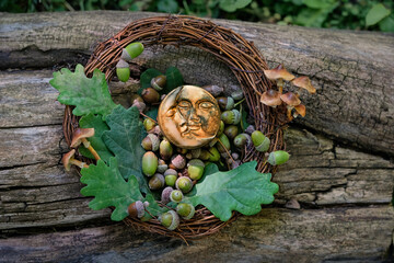 Sticker - symboling moon amulet, acorns, oak leaves and wreath of branches on tree trunk, natural abstract background. forest harvest. magic ritual, witchcraft, spiritual esoteric wiccan or druids practice.