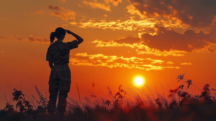 Wall Mural - A woman in a military uniform stands in a field and looks up at the sun