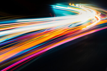 A vibrant array of light streaks dash across a dark background, creating an energetic and futuristic display of motion and color.