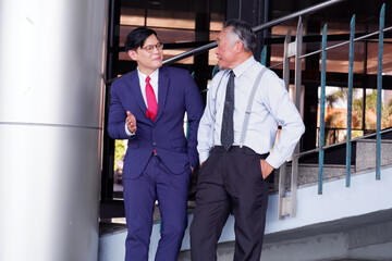 Businessman standing smiling and discussing work in office.