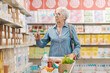 © StockPhotoPro - Elderly woman doing grocery shopping at the supermarket