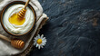 © K2Kstock - Yoghurt with honey in a wooden bowl on a stone table with with empty space for text