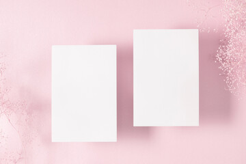 Wall Mural - white paper empty blank, dry flowers, dried twig on pink background. invitation card mockup on pink 