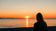 © gustavo - a woman watching a sunset on a torpical beach generated with artificial intelligence