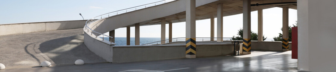 Wall Mural - Empty outdoor car parking lot with ramp on sunny day, banner design