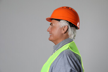 Wall Mural - Engineer in hard hat on grey background, space for text