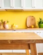© panattar - Part of wood island table in yellow kitchen background ,mock-up stand for product