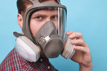 Wall Mural - Man in respirator mask on light blue background