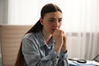 © New Africa - Embarrassed woman in denim jacket in office