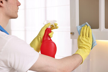 Sticker - Professional janitor cleaning cabinet in kitchen, closeup