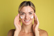 © New Africa - Beautiful woman with cream on her face against olive background