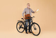© New Africa - Postman with bicycle delivering letters on beige background