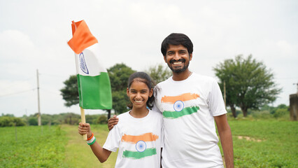 Young and Little Indian holding or waving Indian Tricolor Flag celebrating Independence day or Republic day