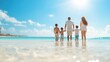 © BoOm - A family enjoying a sunny day at the beach, walking hand in hand on the shoreline with clear blue skies and water.