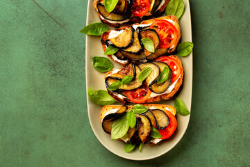 Sticker - Open sandwiches or panino with soft grilled bread, robiolla cheese, tomato and roasted eggplant with basil leaves. Directly above with copy space.