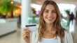© AlfaSmart - Smiling woman holding up a credit card