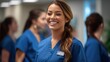 © kartolo - Smiling Female Nurse in Blue Scrubs with Name Tag