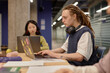 © Seventyfour - Side view of young nonconforming dreadlocked male student practicing writing skills studying on laptop while sitting at large desk at university group seminar