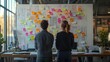 © ae - Two People Planning a Project Using Sticky Notes