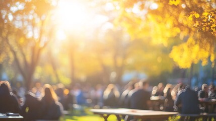 Crowd seated at picnic tables under yellow-leaved trees, enjoying a sunny autumn day