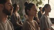 © Pascal - group meditation in yoga studio, breath exercise, men and women meditating and breathing with closed eyes, breathwork concept