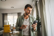 © Miljan Živković - Portrait of adult men stand hold glass of water and mobile phone