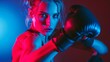 © Vitalii But - female boxer, illuminated by a vibrant red and blue light, throws a punch in the boxing ring. Her intensity is palpable as she focuses on her target.