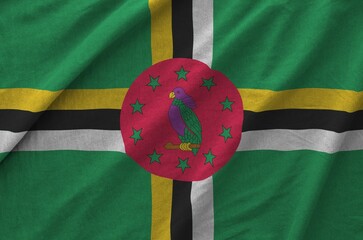 Wall Mural - Dominica flag depicted on folded wavy fabric of old cloth close up