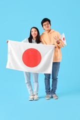 Sticker - Young Asian couple with flags of Japan on blue background