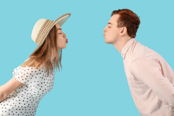 Poster - Young couple kissing on blue background