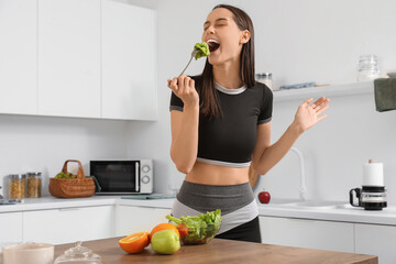 Sticker - Beautiful young happy woman with bowl of fresh salad and fruits at home. Weight loss concept