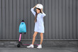 © Pixel-Shot - Cute schoolgirl with electric scooter putting her helmet on outdoors