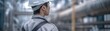 © Chanoknan - A construction worker in a hard hat observes the industrial site, showcasing safety and diligence in a modern work environment.