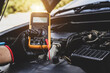 © Eakrin - Car mechanic use voltmeter to check voltage battery low energy problem for car care service maintenance and re charger or jump start or change battery replacement.