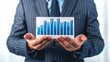 © AKE - Businessman presenting a bar graph showing growth and data analysis in a professional setting.