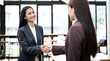 © NAMPIX - Businesswoman handshake and business people. Successful business concept. Banner background, panoramic view..