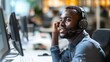 © Ameer - Professional black male customer service representative working in a call center office, providing telemarketing and CRM support while consulting on a headset